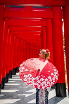 Asian girl in kimono and umbrella in Japanese theme park Hinoki Land in Chai Prakan District, Chiang Mai