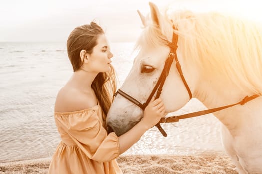 A woman in a dress stands next to a white horse on a beach, with the blue sky and sea in the background