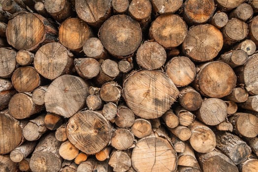 Wall made with a pile of chopped logs of different sizes. log pile background