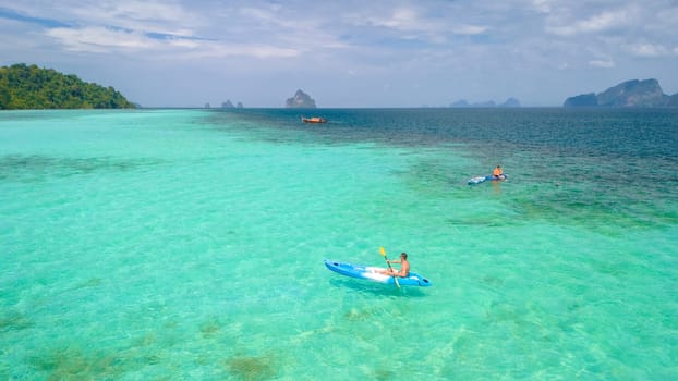 Young men in a kayak at the bleu turqouse colored ocean of Koh Kradan a tropical island with a coral reef in the ocean, Koh Kradan Trang Thailand