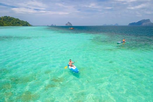 Young man in a kayak at the bleu turqouse colored ocean of Koh Kradan a tropical island with a coral reef in the ocean, Koh Kradan Trang Thailand