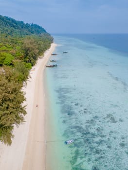 Drone aerial view at Koh Ngai island with palm trees and soft white sand, and a turqouse colored ocean in Koh Ngai Trang Thailand