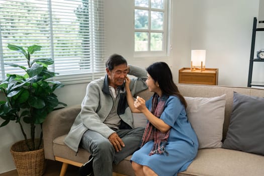 Older couples sit and chat and head over each other relaxed and happy on sofa at home on weekday in comfortable.
