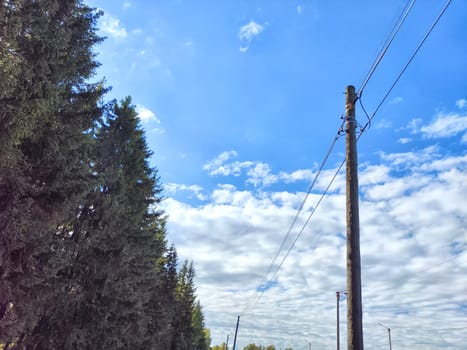 Old power line pole against blue sky in a nice sunny day