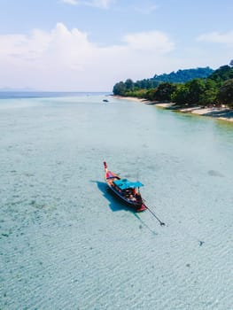 longtail boat in the blue green turqouse colored ocean with clear water at Koh Kradan a tropical island in Trang Thailand