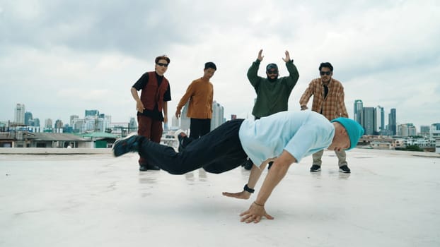 Professional break dance team practice B-boy dance while multicultural friends at rooftop. Young modern dancing group doing hip hop movement. Style,fashion,action. Outdoor sport 2024. Endeavor.