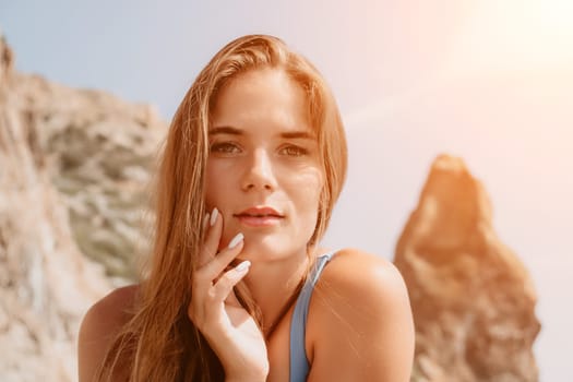 Woman travel sea. Young Happy woman in a long red dress posing on a beach near the sea on background of volcanic rocks, like in Iceland, sharing travel adventure journey