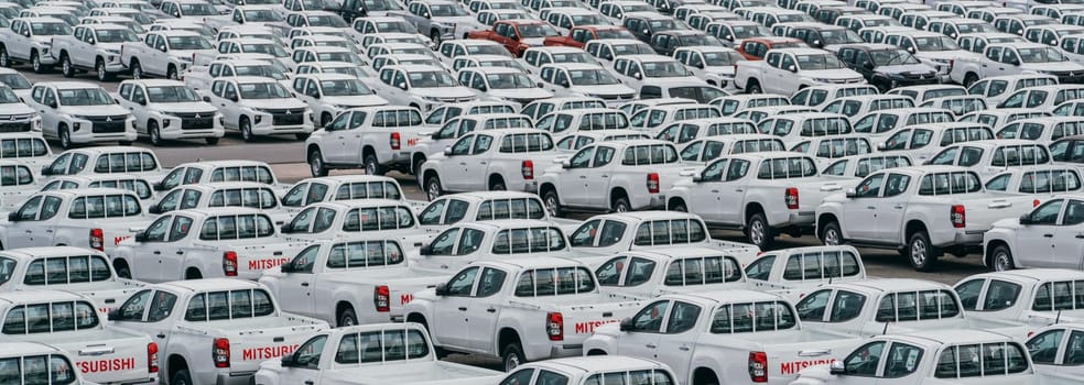 Lamchabang, Thailand - July 02, 2023 A cloudy day at the car factory's distribution center showcases numerous new hatchbacks. The top view captures the crowded parkinga symbol of modern manufacturing.