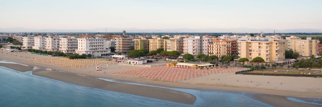 Drone view of sandy beach with umbrellas and gazebos.Summer vacation concept.Lido Adriano town,Adriatic coast, Emilia Romagna,Italy.