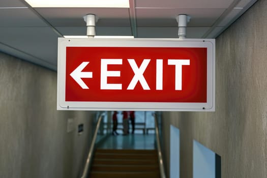 The Exit sign glowing in red shows the word EXIT to doorway. Generative AI..