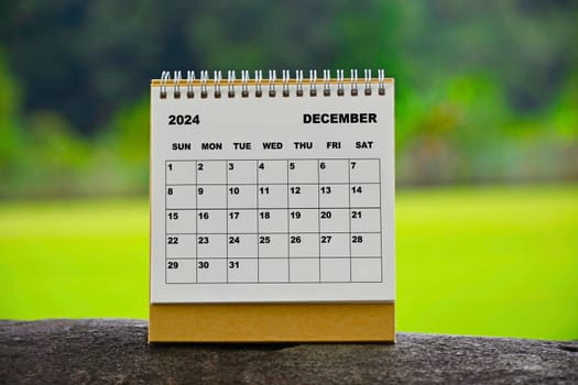 December 2024 white calendar with green blurred background - New year concept.