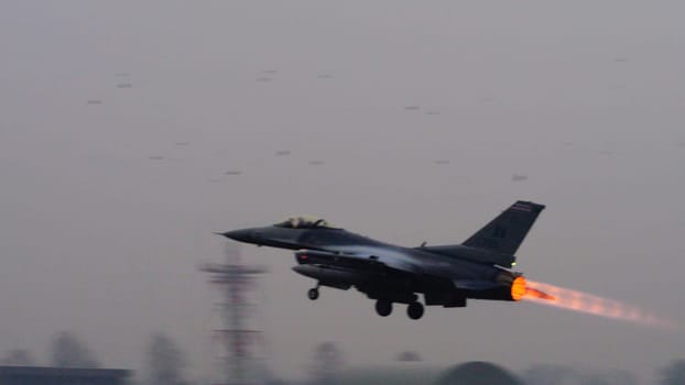 US combat aircraft takes off, its afterburner flame stark against the backdrop, ready to safeguard NATO airspace from any threat including terrorist. Copy Space