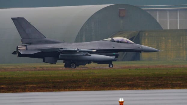 American combat aircraft on the runway, braving severe weather conditions, ready for takeoff. Copy Space. Lockheed F-16 Fighting Falcon of United States Air Force.