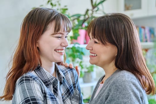 Close-up profile portrait of mother and daughter 18-20 years old. Family, communication, motherhood, friendship, relationship between parent and teenage daughter, mothers Day concept