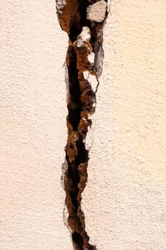Big crack in the white wall close up