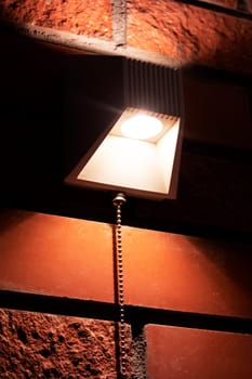 Modern lamp on a red brick wall close up