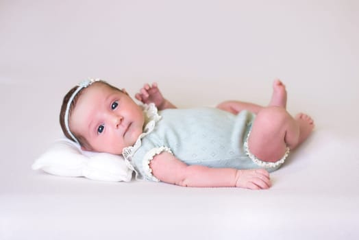 Tiny newborn girl in white cocoons on a white background. Professional studio photography.
