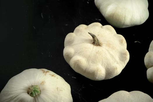 Closeup detail - group of white pattypan squash on black board