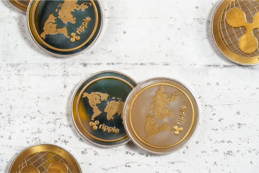 XRP ripple cryptocurrency  golden coins on white stone like board, top down view