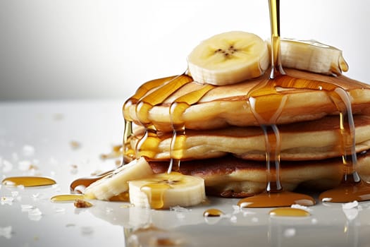 Stack of pancakes with syrup and banana slices.