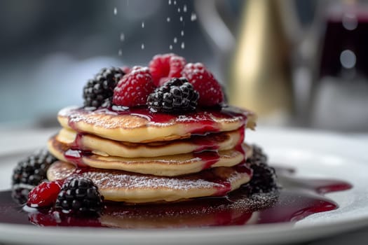Stack of pancakes with berries and syrup.