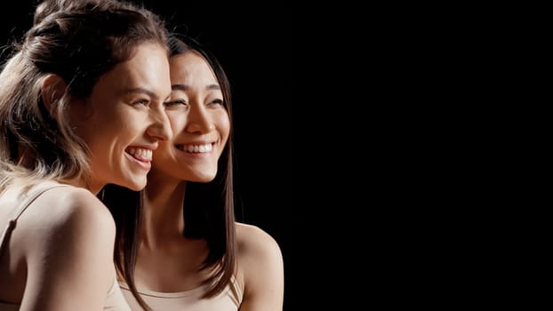 Diverse happy girls hugging each other in beauty ad, feeling flawless and cheerful about skincare campaign. Two beautiful women posing on camera promoting body acceptance and diversity.