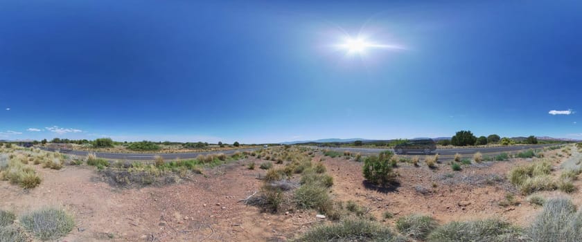 Panoramic view of a sunny desert road in Sedona, Arizona, 2016, highlighting the vastness of the arid landscape and the adventure of travel.