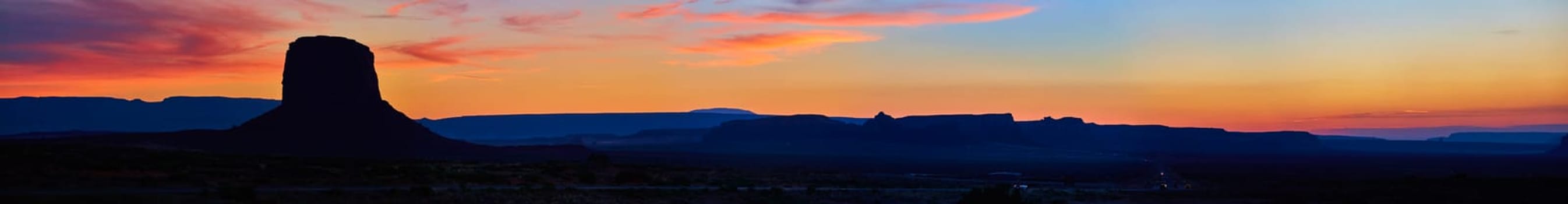 Golden Hour Butte Silhouette in Sedona, 2016 - Panoramic view of an isolated butte against a vibrant sunset sky in Arizona's desert wilderness