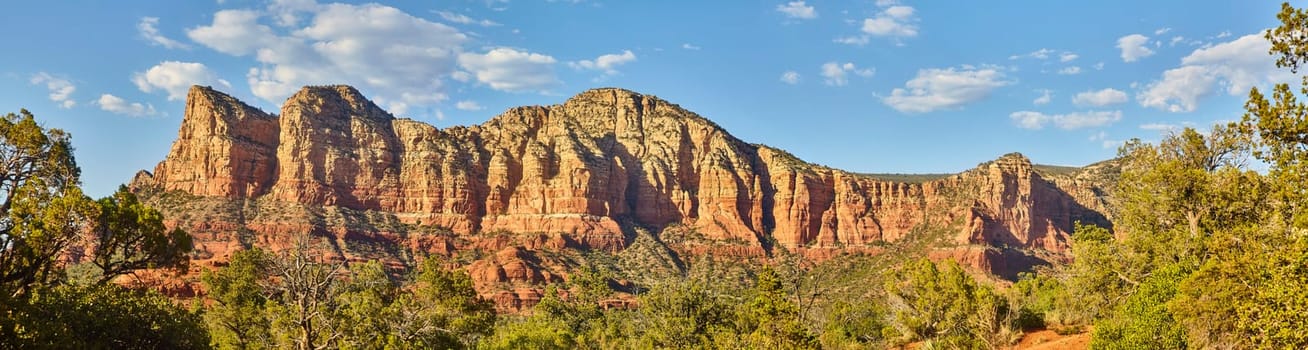 Daytime panorama of Sedona's rugged, red rock mountain range and vibrant desert vegetation, capturing Arizona's natural beauty in 2016.