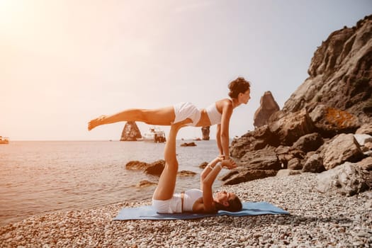 Woman sea yoga. Back view of free calm happy satisfied woman with long hair standing on top rock with yoga position against of sky by the sea. Healthy lifestyle outdoors in nature, fitness concept.