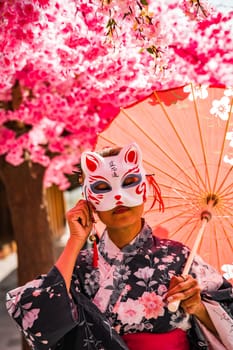 Asian girl in kimono and umbrella in Japanese theme park Hinoki Land in Chai Prakan District, Chiang Mai