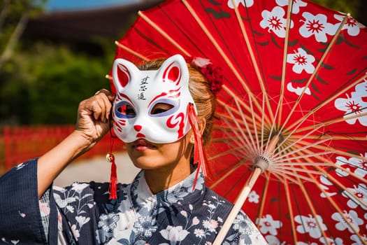 Asian girl in kimono and umbrella in Japanese theme park Hinoki Land in Chai Prakan District, Chiang Mai