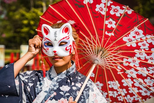 Asian girl in kimono and umbrella in Japanese theme park Hinoki Land in Chai Prakan District, Chiang Mai