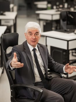 Portrait of a mature business man sitting in a chair in the office