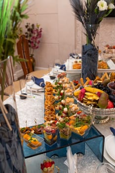 An array of mouthwatering appetizers and a refreshing fruit platter beautifully presented on a glass table, perfect for elegant weddings, corporate gatherings, and intimate private parties.
