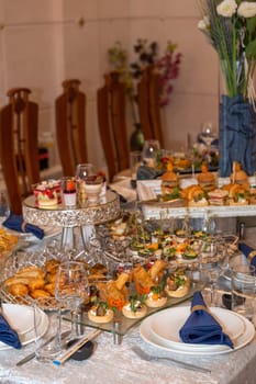 A beautifully set table adorned with a variety of delicious treats and refreshing beverages. Chairs elegantly arranged, creating a sophisticated and inviting atmosphere, perfect for a special event.