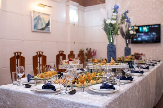 A luxurious table is adorned with delectable dishes, sparkling glassware, and elegant floral centerpieces, creating a perfect setting for a special celebration or sophisticated dining experience.