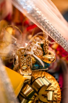 This image showcases a pair of adorable gold baby shoes with a white bow on a white and gold background. The shoes are isolated, making them a fashionable accessory for baby outfits.