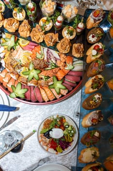 A stunning display of sumptuous sushi and canapes on a glass table, featuring artfully arranged seafood and colorful toppings, creating a feast for the senses. Perfect for any party or event.