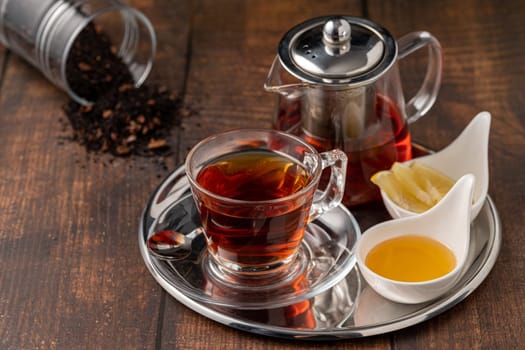 Top view of traditional black turkish tea with lemon and honey on wooden background