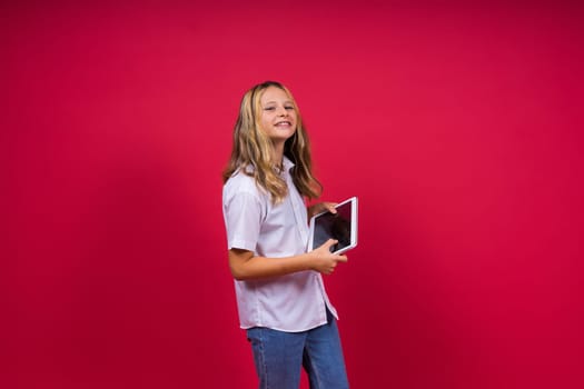 Online school app. Schoolgirl showing tablet computer Empty Screen On red Background. Studio Shot