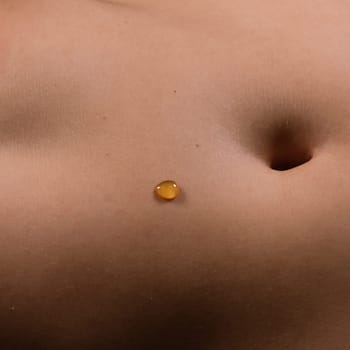 Beautiful female body in honey on a dark background, studio