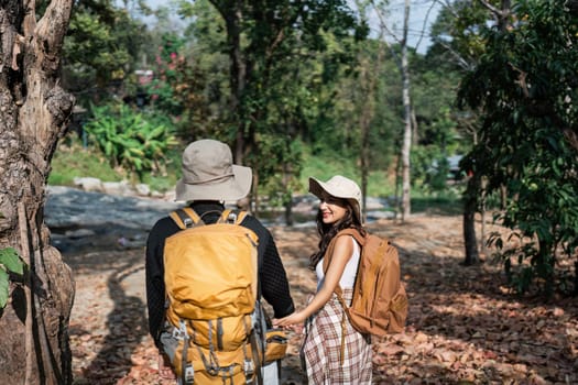 Happy LGBT Lesbian couple Travelers Hiking with Backpacks in forest Trail. LGBT Lesbian Couple Hikers with backpacks walks in mountains in vacation.