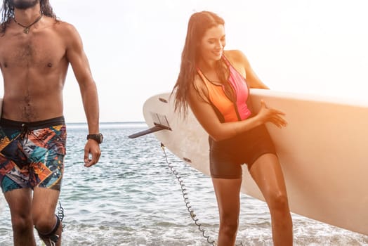 Sea woman and man on sup. Silhouette of happy young woman and man, surfing on SUP board, confident paddling through water surface. Idyllic sunset. Active lifestyle at sea or river