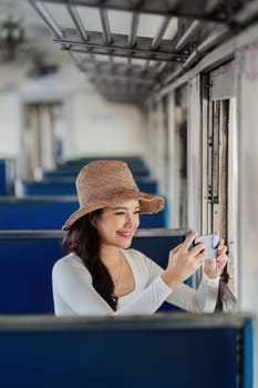 Happy young woman using mobile and talking picture during transport on travel vacation.