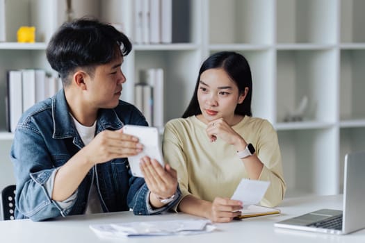 Stressed couple calculating monthly expenses at home. Financial, debt and accounting concept.