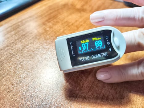 Close up of hand with a pulse oximeter on the finger.