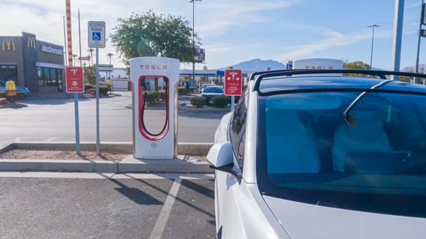 Primm, Nevada, USA-December 3, 2022-During the day, a Tesla vehicle is seen charging at a Tesla Supercharging station, utilizing the high-speed charging infrastructure for convenient and efficient electric vehicle refueling.
