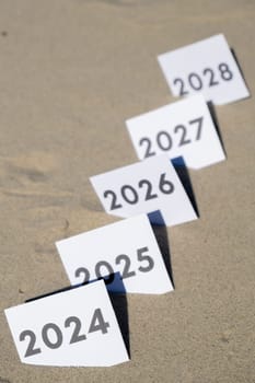 Paper cards with numbers of years from 2024 to 2028 in a row. New year start concept. Resolution time is flying plan goal motivation countdown