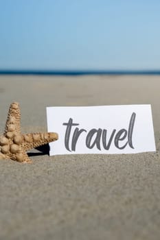 TRAVEL text on paper greeting card on background of starfish seashell summer vacation decor. Sandy beach sun coast. Holiday concept postcard. Getting away Travel Business concept